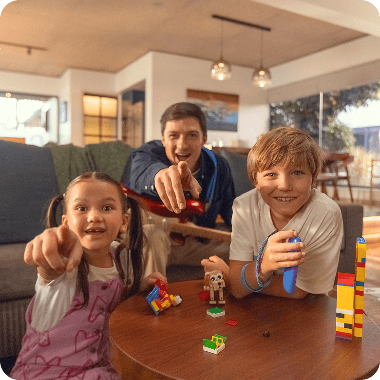 Kids and parent playing with blocks, smiling at camera